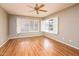 Bedroom with a ceiling fan, wood-look flooring and window shutters for soft natural light at 1538 E Peach Tree Dr, Chandler, AZ 85249