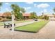 Exterior shot of lawn bowling area with benches and shade and lush landscaping, perfect for outdoor recreation at 1538 E Peach Tree Dr, Chandler, AZ 85249