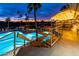 Beautifully lit pool area at dusk with palm trees and a relaxing ambiance, showcasing the community's recreational offerings at 1538 E Peach Tree Dr, Chandler, AZ 85249