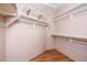 Walk-in closet with wood-look floors and adjustable shelving and clothing rods at 1538 E Peach Tree Dr, Chandler, AZ 85249