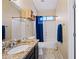 Cozy bathroom featuring a bathtub with blue shower curtain, granite vanity, and linen storage at 15646 N 20Th Ave, Phoenix, AZ 85023