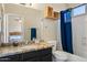 Bathroom featuring granite countertops, a shower with blue curtain, and bedroom access through a mirror at 15646 N 20Th Ave, Phoenix, AZ 85023