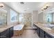 Elegant bathroom with a soaking tub, glass-enclosed shower, and dual vanities with granite countertops at 15646 N 20Th Ave, Phoenix, AZ 85023