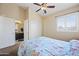 Bright bedroom featuring a ceiling fan, light-colored walls, and ensuite bathroom access for added privacy at 15646 N 20Th Ave, Phoenix, AZ 85023