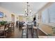 Open-concept dining area with modern lighting, stylish bar stools, and beautiful hardwood floors at 15646 N 20Th Ave, Phoenix, AZ 85023