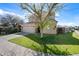 Two-story home boasts a neutral exterior, tidy lawn, and charming landscaping with a mature shade tree at 15646 N 20Th Ave, Phoenix, AZ 85023