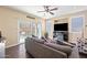 Inviting living room featuring a comfortable gray couch, ceiling fan, and sliding glass doors to the patio at 15646 N 20Th Ave, Phoenix, AZ 85023