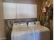 Functional laundry room with white cabinets above a modern washer and dryer set at 17200 W Bell Rd # 2301, Surprise, AZ 85374