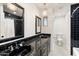 Chic black and white bathroom with dual sinks, decorative mirrors, and a chandelier lighting fixture at 1801 E Berridge Ln, Phoenix, AZ 85016