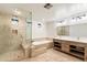 Bright bathroom featuring double vanity, soaking tub, and walk-in shower with glass surround at 1801 E Berridge Ln, Phoenix, AZ 85016