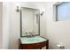 Stylish bathroom with a light turquoise vanity, decorative wall sconces, and silver-trimmed mirror at 1801 E Berridge Ln, Phoenix, AZ 85016