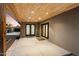 Covered patio with concrete flooring and wood plank ceiling, featuring multiple entry points to the home at 1801 E Berridge Ln, Phoenix, AZ 85016