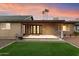 Covered patio with modern glass doors and a well-manicured lawn, creating an inviting outdoor space at 1801 E Berridge Ln, Phoenix, AZ 85016