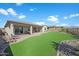 Well-manicured backyard featuring artificial turf, patio area, and a low-maintenance landscape at 18601 W Thunderhill Pl, Goodyear, AZ 85338