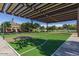 A view of a shaded community basketball court with a view of a lake at 18601 W Thunderhill Pl, Goodyear, AZ 85338