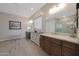 Bright bathroom featuring dual vanities and large mirrors, enhancing functionality and style at 18601 W Thunderhill Pl, Goodyear, AZ 85338