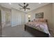 Spacious bedroom featuring a ceiling fan, access to a bathroom and hallways at 18601 W Thunderhill Pl, Goodyear, AZ 85338