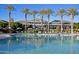 An eye-level view of a sparkling pool with lounge chairs and umbrellas, near a community clubhouse at 18601 W Thunderhill Pl, Goodyear, AZ 85338