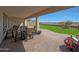 Inviting covered patio with ample seating and views of the artificial turf backyard at 18601 W Thunderhill Pl, Goodyear, AZ 85338