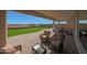 Covered patio featuring outdoor seating and well-maintained artificial turf and landscape at 18601 W Thunderhill Pl, Goodyear, AZ 85338