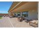 Relaxing covered patio with seating and lounge chairs, overlooking the manicured lawn at 18601 W Thunderhill Pl, Goodyear, AZ 85338