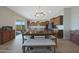 Open dining area features wood table with bench seating and seamless access to the gourmet kitchen at 18601 W Thunderhill Pl, Goodyear, AZ 85338