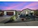 Charming single-story home with stone accents and desert landscaping featuring a variety of cacti and native plants at 18601 W Thunderhill Pl, Goodyear, AZ 85338