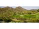 Scenic golf course view with players on the green, surrounded by desert landscape at 18601 W Thunderhill Pl, Goodyear, AZ 85338