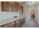 Hallway with cabinets and white countertops, leading into other rooms at 18601 W Thunderhill Pl, Goodyear, AZ 85338