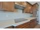 Modern kitchen features an induction cooktop and stainless steel vent hood at 18601 W Thunderhill Pl, Goodyear, AZ 85338