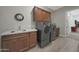 Practical laundry room with modern washer, dryer, sink and ample cabinet space for storage at 18601 W Thunderhill Pl, Goodyear, AZ 85338