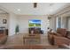 Comfortable seating in an airy living room with hardwood floors, a ceiling fan, and television at 18601 W Thunderhill Pl, Goodyear, AZ 85338