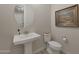 Elegant powder room with a pedestal sink, stylish fixtures and a modern toilet at 18601 W Thunderhill Pl, Goodyear, AZ 85338