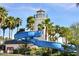 A view of a twisting blue water slide next to a lighthouse-themed structure at the community pool at 18601 W Thunderhill Pl, Goodyear, AZ 85338