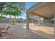 Backyard featuring a covered patio, gravel, privacy fence and mature trees at 19602 N Canyon Whisper Dr, Surprise, AZ 85387