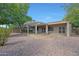 Backyard area features a covered patio, stone pavers, and desert landscaping at 19602 N Canyon Whisper Dr, Surprise, AZ 85387