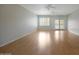 Bright living room with light wood floors, ceiling fans, and access to the outdoors at 19602 N Canyon Whisper Dr, Surprise, AZ 85387