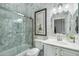 Well-lit bathroom featuring a glass-enclosed shower, toilet, vanity with sink and framed mirror at 2102 E Norwood St, Mesa, AZ 85213