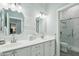 Bathroom with double sinks, white subway tile walls, and glass-enclosed shower at 2102 E Norwood St, Mesa, AZ 85213