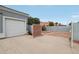 Two car garage adjacent to a gated side yard with a brick-lined planting area at 2102 E Norwood St, Mesa, AZ 85213