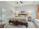 Luxurious main bedroom with carved wood bedframe, carpeted floors, ceiling fan and ensuite bathroom at 2102 E Norwood St, Mesa, AZ 85213