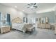 Spacious main bedroom featuring a decorative bed frame, ceiling fan, and ensuite bathroom at 2102 E Norwood St, Mesa, AZ 85213