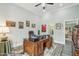 Home office with large desk, wall art, and ceiling fan with chandelier at 2102 E Norwood St, Mesa, AZ 85213