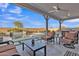 A covered outdoor living space with ample seating that overlooks a pristine pool and manicured landscaping at 21036 E Stacey Rd, Queen Creek, AZ 85142