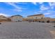 Large gravel backyard with detached structure at the back and view of the main house at 21036 E Stacey Rd, Queen Creek, AZ 85142