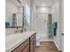 Bathroom featuring a large mirror, subway tile shower with curtain, and wood-look tile floor at 21036 E Stacey Rd, Queen Creek, AZ 85142