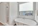 Bright bathroom featuring a soaking tub, walk-in shower, subway tile, and a window with natural light at 21036 E Stacey Rd, Queen Creek, AZ 85142