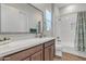 Bathroom featuring a large mirror, subway tile shower with curtain, and wood-look tile floor at 21036 E Stacey Rd, Queen Creek, AZ 85142