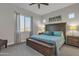 Cozy bedroom featuring a wooden bed frame with a blue quilt, large window, and wood-look ceiling fan at 21036 E Stacey Rd, Queen Creek, AZ 85142