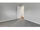 Simple bedroom with neutral walls and carpet, featuring an open door and electrical outlets at 21036 E Stacey Rd, Queen Creek, AZ 85142